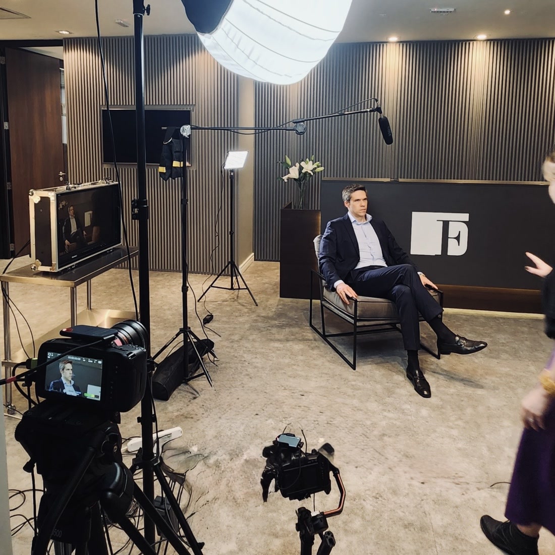 Entrevista gravada em consultório, com poltrona, microfone boom e monitor de referência